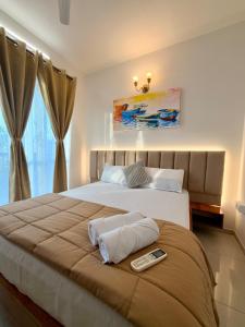 a bedroom with a bed with a remote control on it at Bay Breeze 2BR Apt Amoret Homes in Chicalim +17 photos