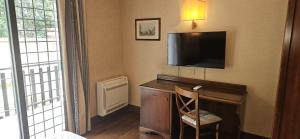 a room with a desk with a television on a wall at Appia Park Hotel in Rome