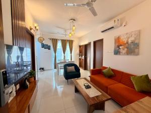 a living room with a red couch and a tv at Bay Breeze 2BR Apt Amoret Homes in Chicalim