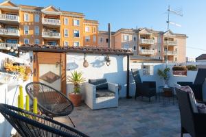 a patio with chairs and tables and buildings at Cozy guest house Downtown in Olbia