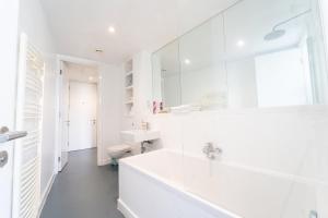 a white bathroom with a tub and a sink at THE OLIVE SUITE At The Rotunda in Birmingham +23 photos