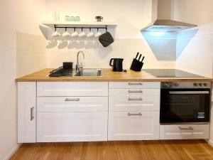 a kitchen with white cabinets and a sink at Altstadtidyll in Lübbenau