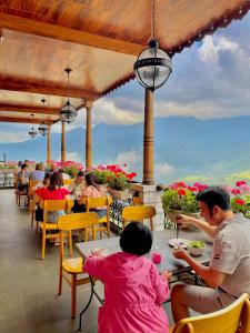 a group of people sitting at tables on a patio at SAPA DEBOUTIQUE Hotel in Sapa
