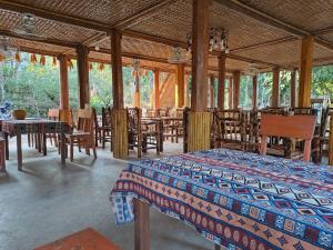 a room with a bed and some tables and chairs at Muong Bi Homestay - Uncle Lon - Luy Ai village in Hòa Bình