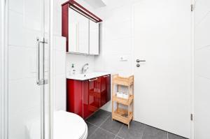 a bathroom with a red sink and a toilet at 2 bedroom flat Bonnevoie - sleeps 7 in Luxembourg +25 photos