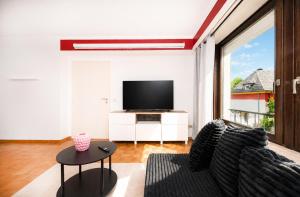 a living room with a tv and a couch and a table at 2 bedroom flat Bonnevoie - sleeps 7 in Luxembourg