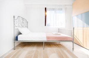 a bed in a white room with a window at 2 bedroom flat Bonnevoie - sleeps 7 in Luxembourg