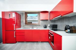 a red kitchen with a sink and a window at 2 bedroom flat Bonnevoie - sleeps 7 in Luxembourg