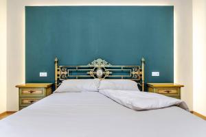 a bedroom with a large bed with a blue wall at Villa Zina in Pasiano di Pordenone