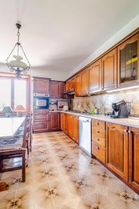 a large kitchen with wooden cabinets and a table at Villa Zina in Pasiano di Pordenone