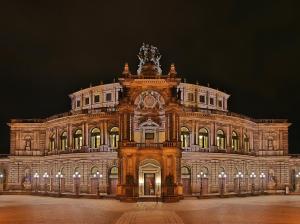 un grand bâtiment avec une horloge la nuit dans l'établissement Dresden grüßt seine Gäste, à Dresde