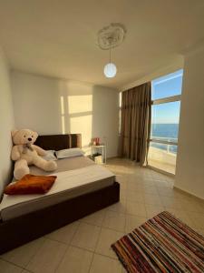 a teddy bear sitting on a bed in a bedroom at HRS Luxury Apartments in Durrës