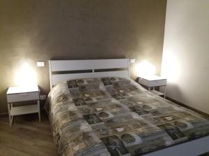 una camera da letto con un grande letto con due comodini di Casa Silve a La Spezia