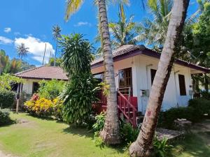 a house with palm trees in front of it at Koh kood Neverland beach resort in Ko Kood +28 photos