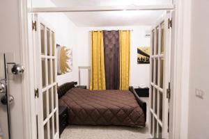 una piccola camera con letto e tende gialle di Metropolitan b&b a Bari