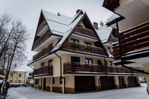 budynek z pokrytym śniegiem dachem na górze w obiekcie Zacisza Tetmajera w Zakopanem