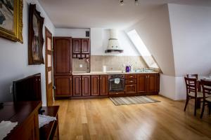 a kitchen with wooden cabinets and a table with chairs at Zacisza Tetmajera in Zakopane