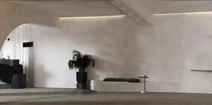 a living room with a potted plant and a wall at Mamay Hotel in Fira
