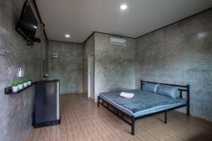 a bedroom with a bed and a television in it at Sun Resort in Sa Kaeo