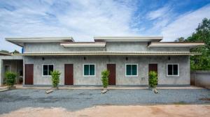 a building with two doors and two plants in front at Sun Resort in Sa Kaeo +9 photos
