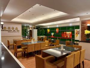 a dining room with tables and chairs in a restaurant at Macau Masters Hotel in Macau