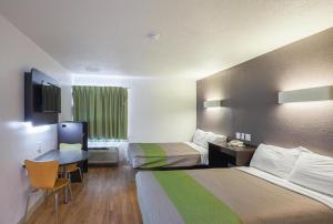 a hotel room with two beds and a desk at Studio 6 Buttonwillow, CA in Bowerbank