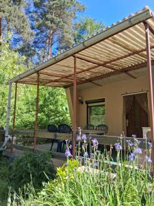 a wooden pergola over a table and chairs at Bungalow im Künstlergarten in Bad Muskau