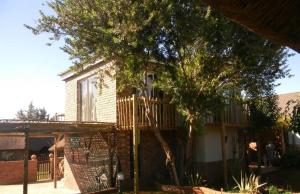 a house with a deck on the side of it at La Postma House in Postmasburg