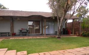 a house with a tree in the yard at La Postma House in Postmasburg +3 photos
