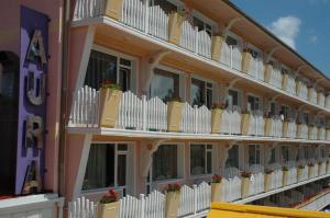 a building with white fences and flowers on the balconies at Balneo & SPA Hotel Aura in Velingrad