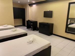 a hotel room with two beds and a flat screen tv at Hotel Benjamin Naval in Biliran