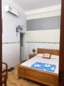 a bedroom with a bed with a blue blanket on it at MyDungmotel in Danang