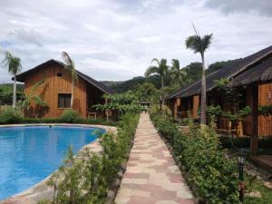 a path leading to a resort with a swimming pool at calayo beach resort in Calayo