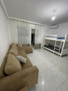 a living room with a couch and a bunk bed at Hotel Infinity Shëngjin in Lezhë