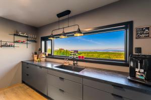 a kitchen with a sink and a large window at Villa Walter Lofoten with SAUNA in Kvalnes
