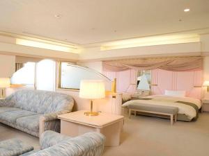 uma sala de estar com uma cama e um sofá em Rihga Royal Hotel Niihama em Niihama