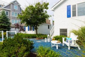 a garden with a table and chairs and a house at Blue - Inn on the Beach in Newburyport
