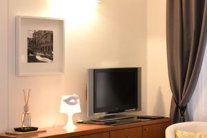 TV de pantalla plana en la parte superior de un armario de madera en Sweet Apartment, en Venecia