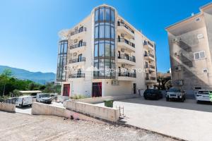 a large building with cars parked in a parking lot at Green Oasis Bečići in Boreti