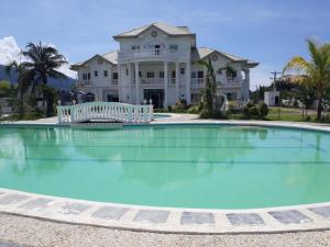 a large swimming pool in front of a house at Andres Resort in Nabas
