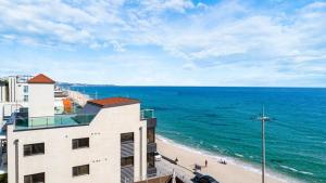 a view of a beach with a building and the ocean at Gangneung Dolgorae Spa Pension in Gangneung