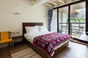 una camera da letto con un letto con una coperta rossa di Haku Beach Days Inn a Nanwan