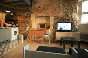 sala de estar con pared de ladrillo y TV en Le Cottage, en Saint-Sébastien-sur-Loire