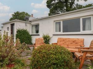 a house with two wooden benches in the yard at 7 Chycoose Parc in Truro