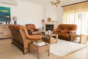a living room with leather furniture and a fireplace at Quinta Vale do Armo in Sardoal