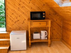 a microwave and a refrigerator on a table in a cabin at Relaxing Loft Getaway Heart of County Meath in Enfield