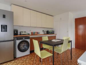 a kitchen with a black table and yellow chairs at 7 Chycoose Parc in Truro
