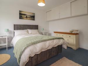 a bedroom with a large bed and a dresser at 7 Chycoose Parc in Truro