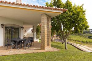 a patio with a black table and chairs under a pergola at Quinta Vale do Armo in Sardoal +14 photos