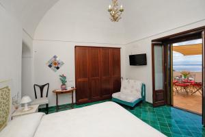 um quarto com uma cama, uma cadeira e uma varanda em Tenuta Mamma Carmela em Amalfi